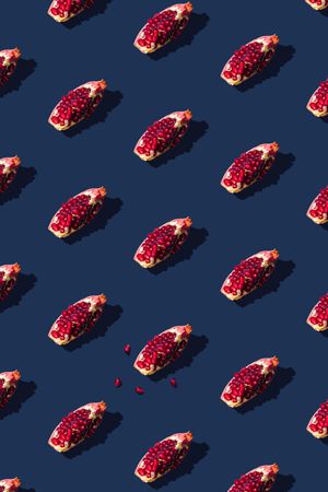 Pattern of pomegranate fruit slices on navy background