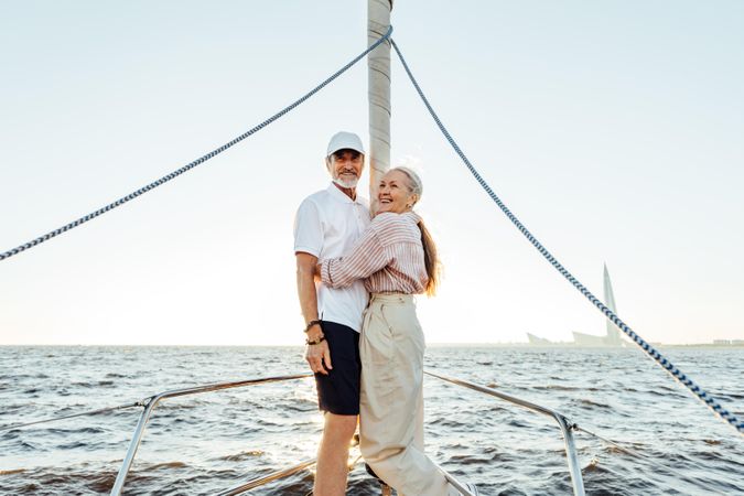 Mature couple enjoying sunset on a sailboat