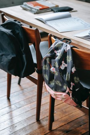 Two backpacks on two chairs in a classroom