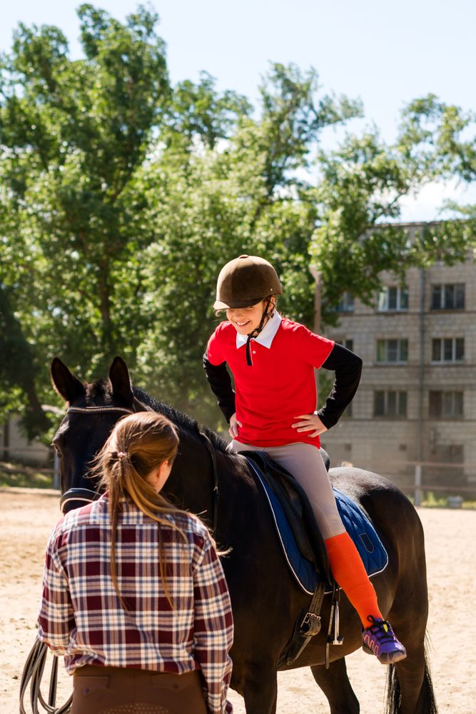 Smiling young rider on horse outdoors.