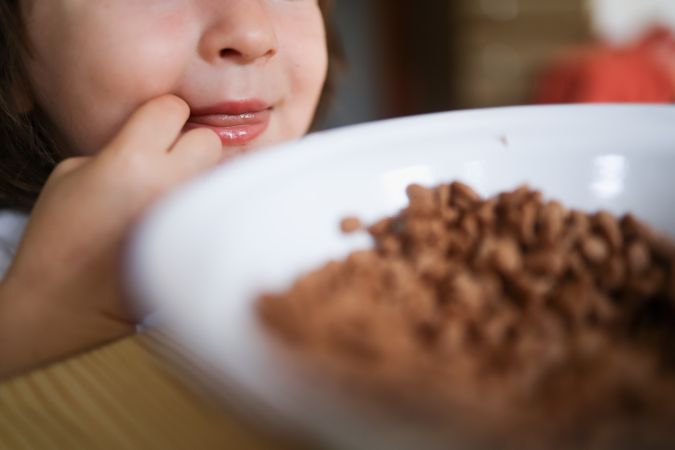 A small kid eating healthy cereals in the morning.