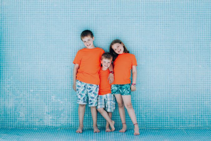 Children standing in empty pool and looking at camera
