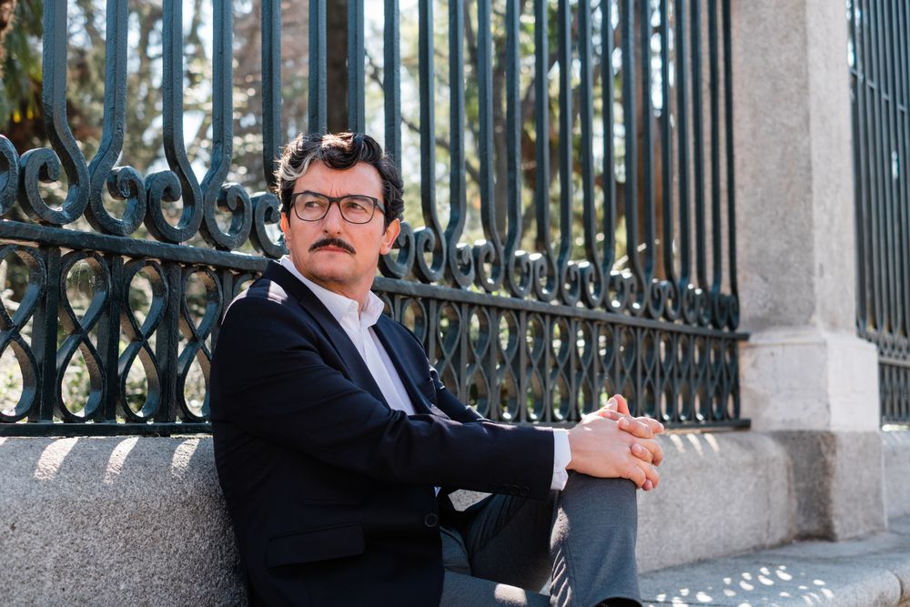 Older accomplished businessman waiting for meeting on bench outdoors