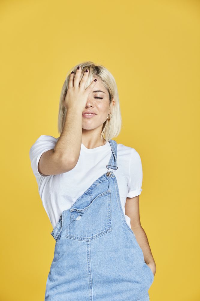 Trendy blonde female in denim sundress