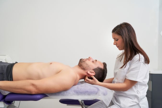 a man receiving migraine treatment at the physiotherapist's office