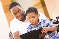 Father and Son Using Digital Tablet Outside