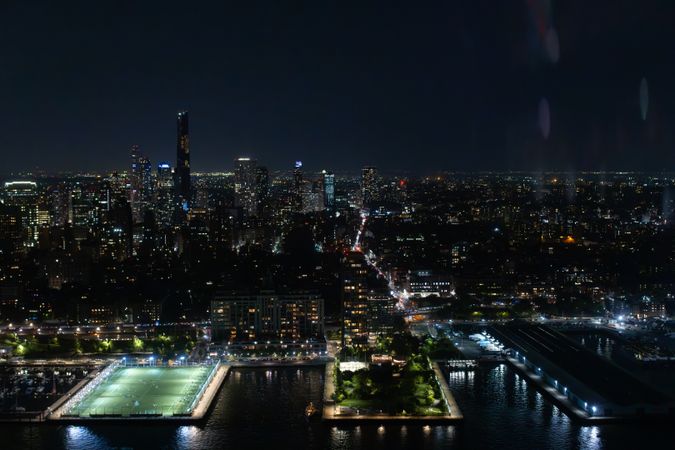 Scenic Aerial New York City View of Downtown Manhattan Architecture. Panoramic Image of the Business District from a Helicopter. Cityscape with Buildings with Lights in Offices at Night