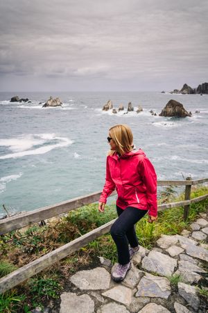 Woman climbing stairs that come from the seashore