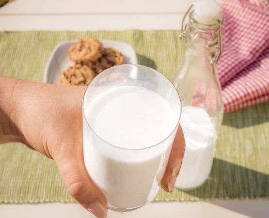 Glass of milk held in hand