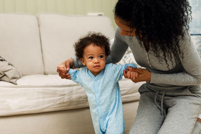 Mother with baby boy as he walks