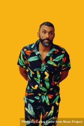 Black male in bold patterned shirt standing in yellow room 4ZY9W5
