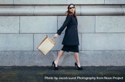 Stylish female shopper walking with shopping bag 0LdaKE