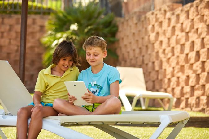Boys using tablet in garden