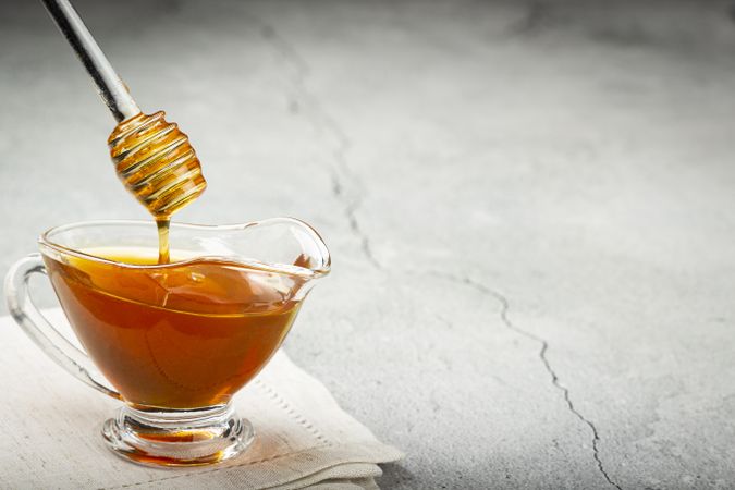 Honey in glass bowl on the table.