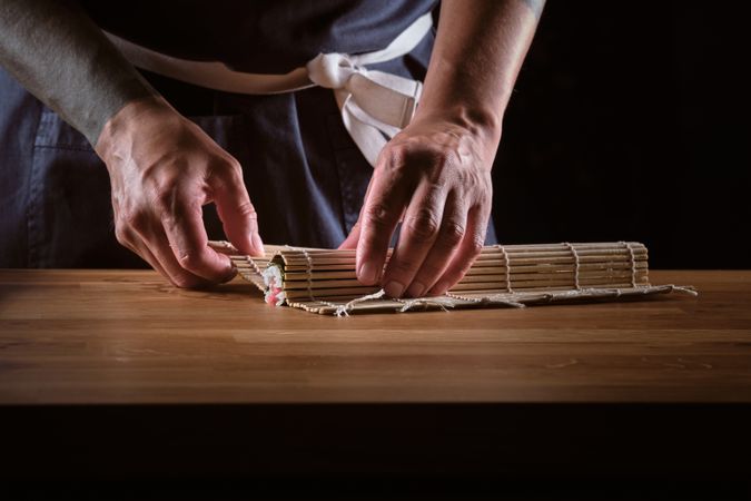 Male shushi man hands preparing different pieces of makis