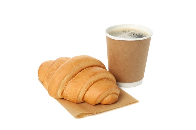 Baked croissant and paper cup isolated on blank background