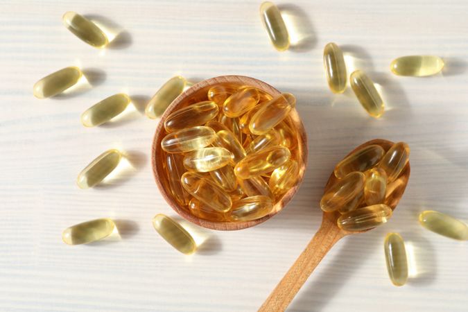 Omega pills in a wooden bowl on a neutral background