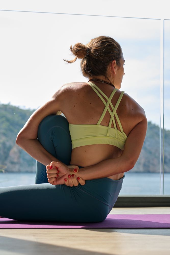 Slim woman practicing yoga in Marichyasana on terrace