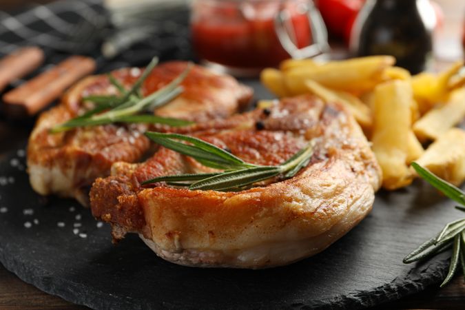 Composition with fried steaks on tray, on wooden background. Grilled food