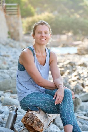 Smiling woman having rest after training in nature