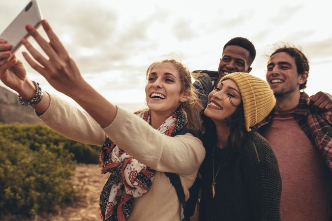 Group of people taking selfie for social media content