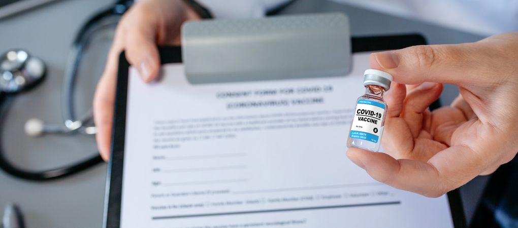 Female doctor's hand showing coronavirus vaccine vial