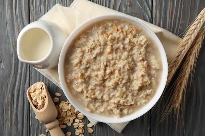 Composition with oatmeal porridge on wooden background. Cooking breakfast