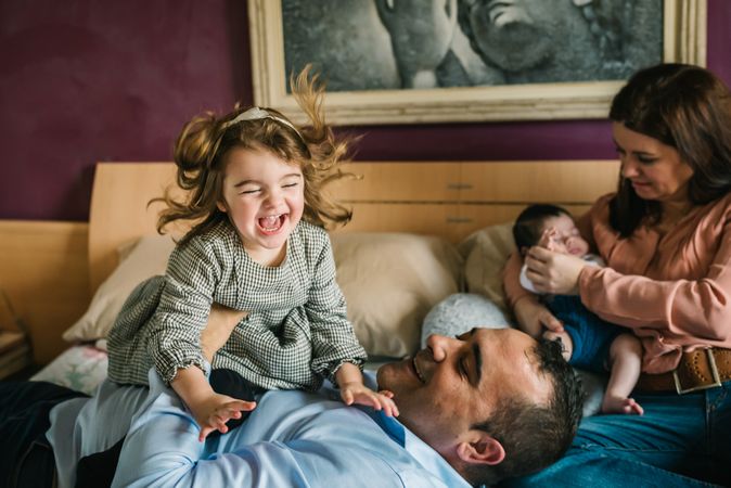 Happy family having fun in bedroom