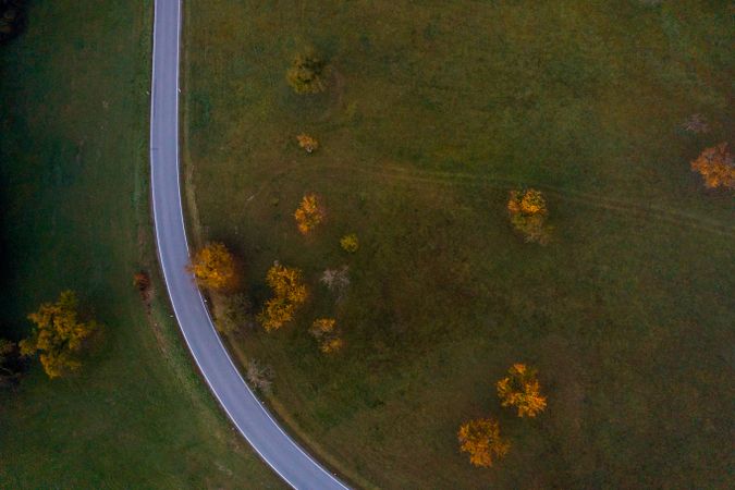 Drone aerial image of a road crossing an autumn orchard on a cold morning in October