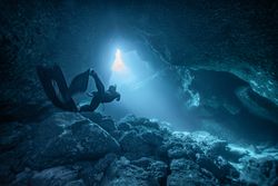 Person diving between rocks