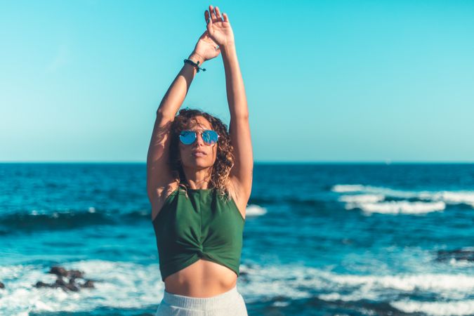 Stylish woman standing near sea