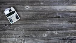 Vintage calculator on old wood desk table