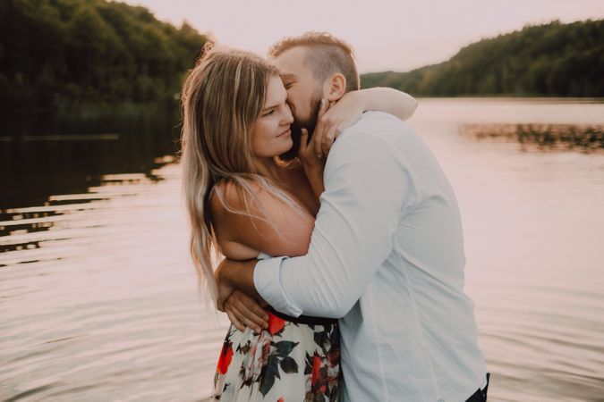 Loving couple standing ankle deep in water on beach