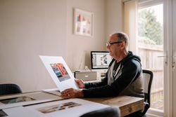 Man considering photos in his home office bEe81b