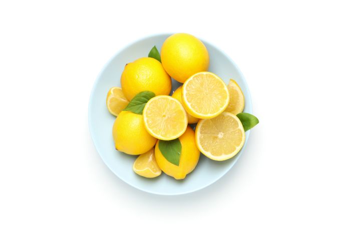 Plate with fresh lemons isolated on bright background