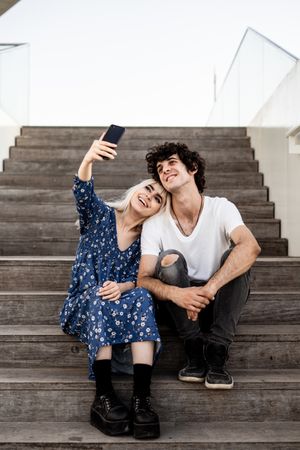 Happy couple taking selfie on street