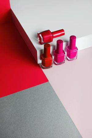 Multi-colored nail polish on pastel colors geometric pattern background