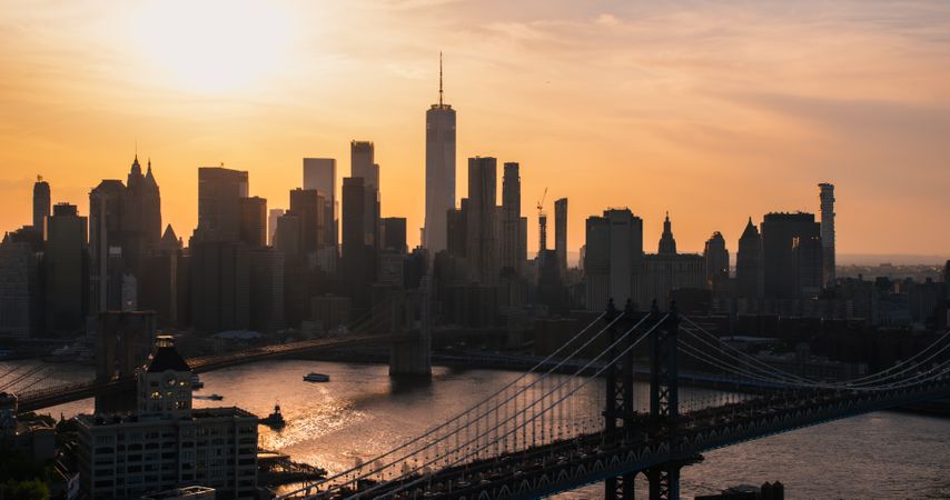 New York City Skyline Aerial Photo from a Helicopter at Sunset. Famous Skyscraper Buildings with Manhattan and Brooklyn Bridges. Busy Diverse Megapolis with Cars, Boats and People Moving Around