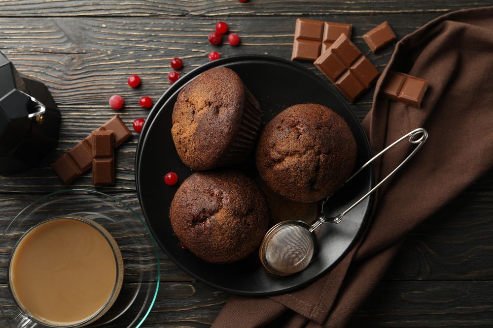 Composition with tasty muffins and cocoa drink on wooden background