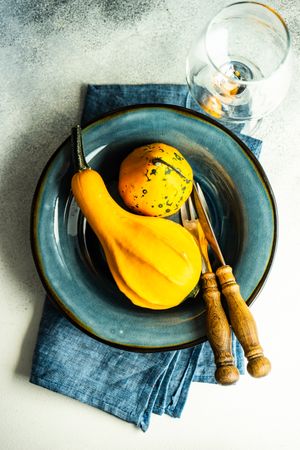 Top view of fall squashes on blue tableware with wineglass