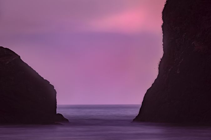 Purple hued sky between two rocks on the Pacific Coast