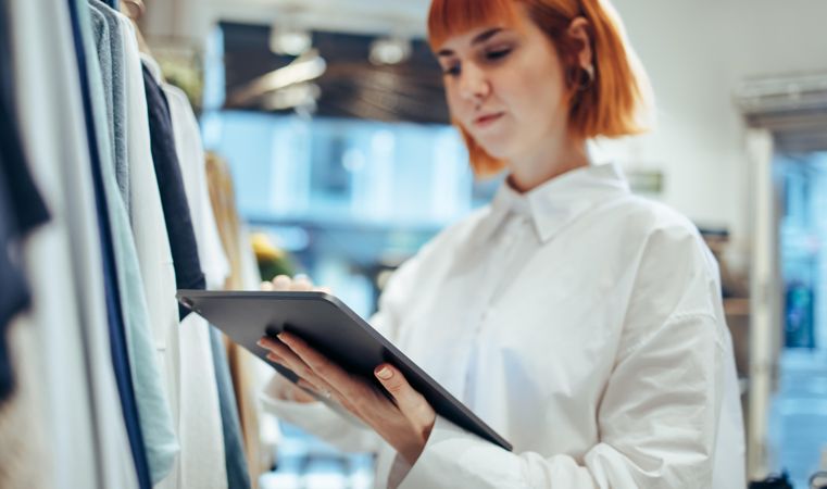 Businesswoman using digital tablet while working in clothing store