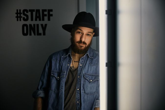 man in hat looking at camera in room