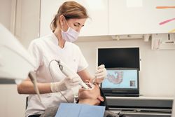 Female orthodontist scanning patient with dental scanner in clinic
