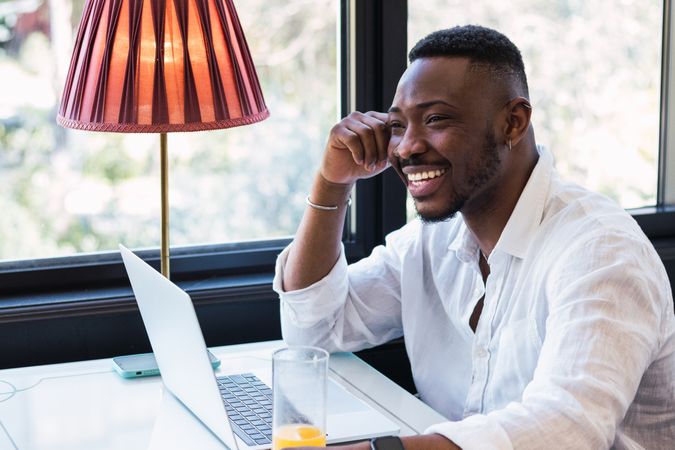 Black man working on laptop in cafe