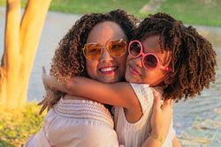 Portrait of a mother and her daughter in the park during summer vacations
