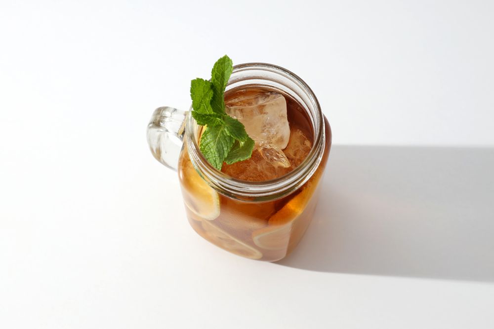 A glass of delicious cold tea on a plain background