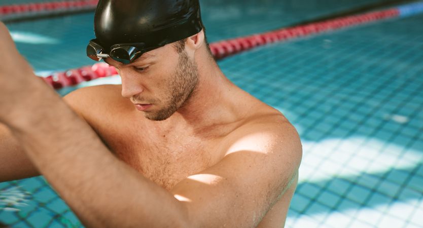 Fit male swimmer preparing to go for a swim