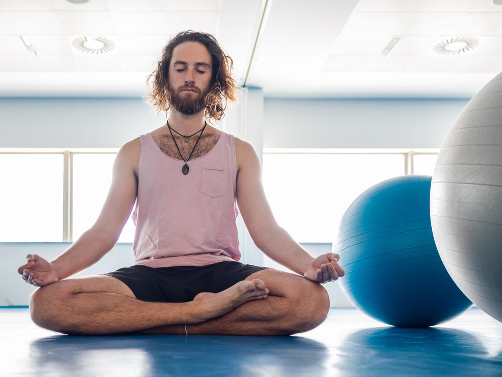 Male meditating in spacious room