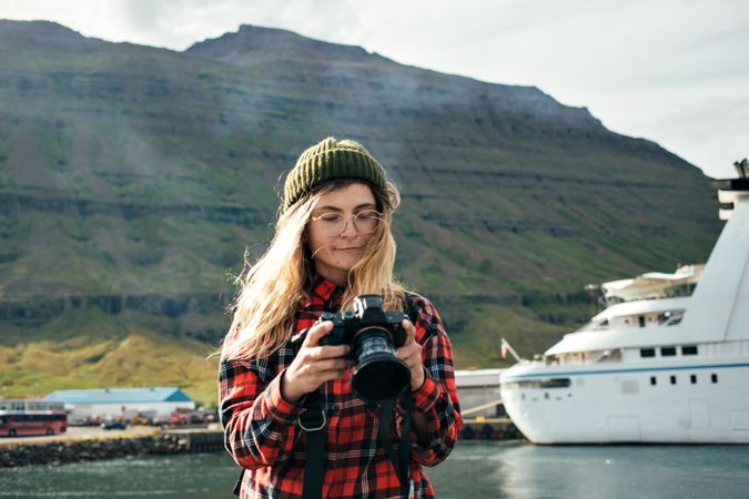 Woman checking photos she took on camera with cruise ship